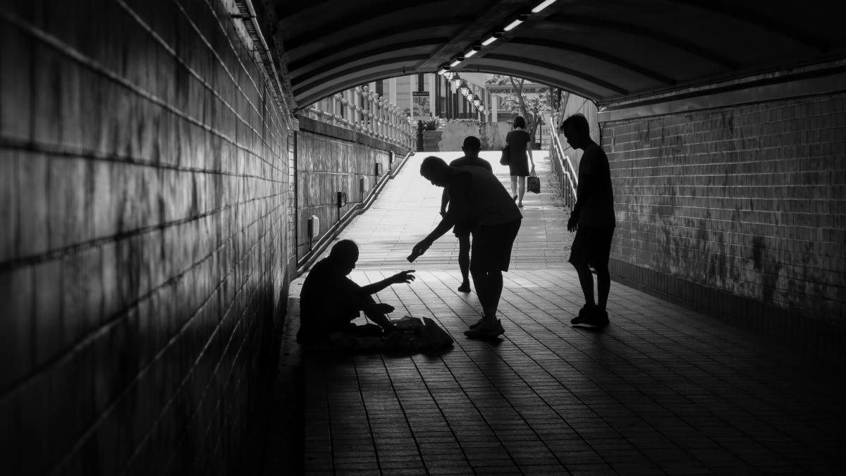 Man in the street being given money (black and white picture)