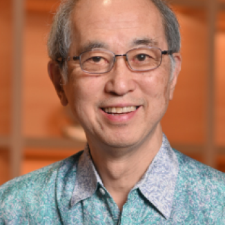 a man in glasses and in a blue green patterned shirt
